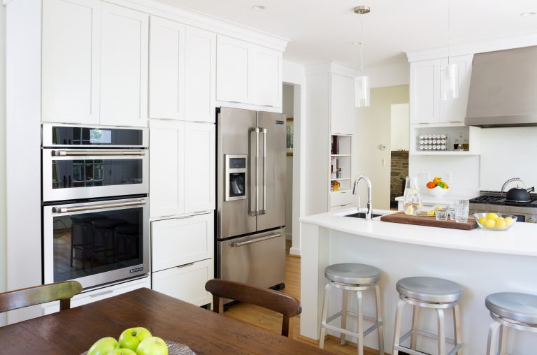 kitchen with white cabinetry and island with seating stainless steel refrigerator and wall oven
