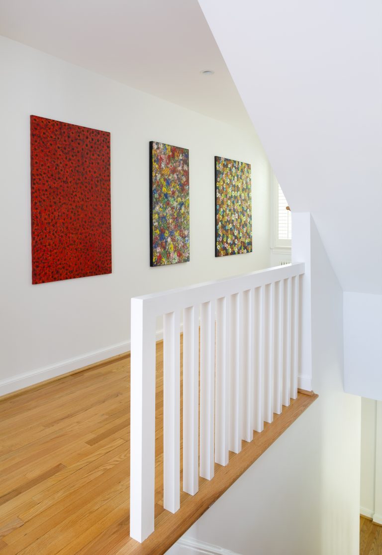 bright white hallway with wood floors and modern abstract art