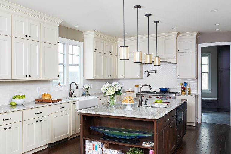kitchen with white outer cabinets and dark cabinetry island with open shelving on side