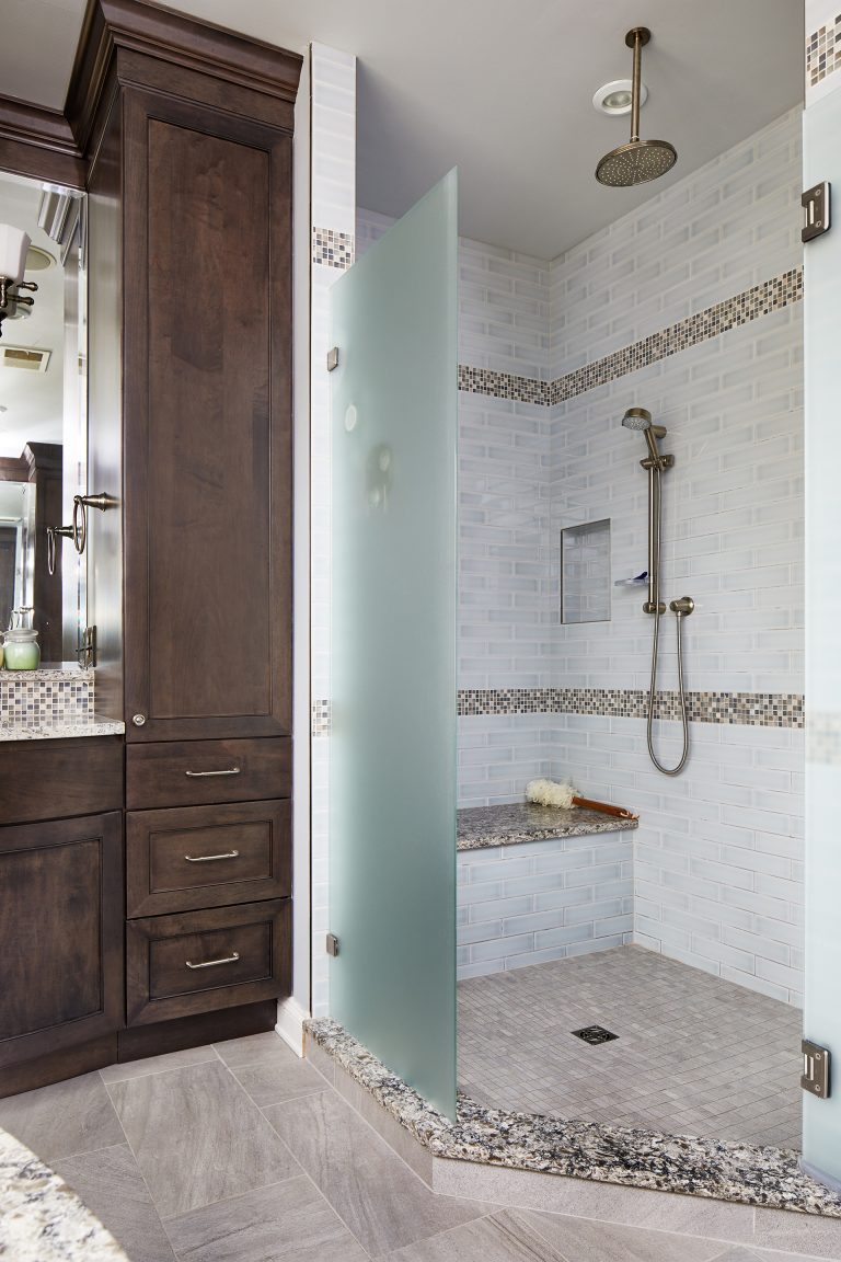 separate shower stall with frosted glass wall rain shower head built in bench and storage nooks mosaic tile stripe detail