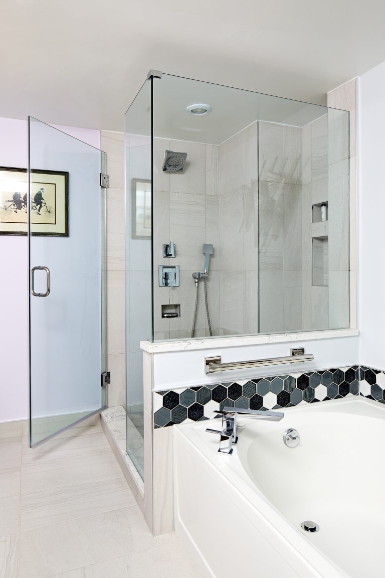 separate bathtub and large shower stall with glass walls