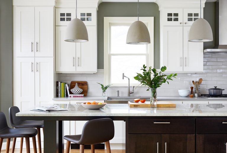 kitchen with wood floors white outer cabinets and dark stained island with seating pendant lighting