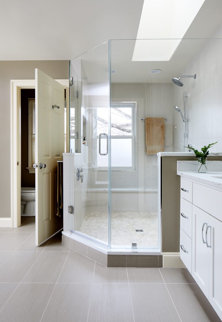 master bathroom with separate water closet large shower two sinks and skylight