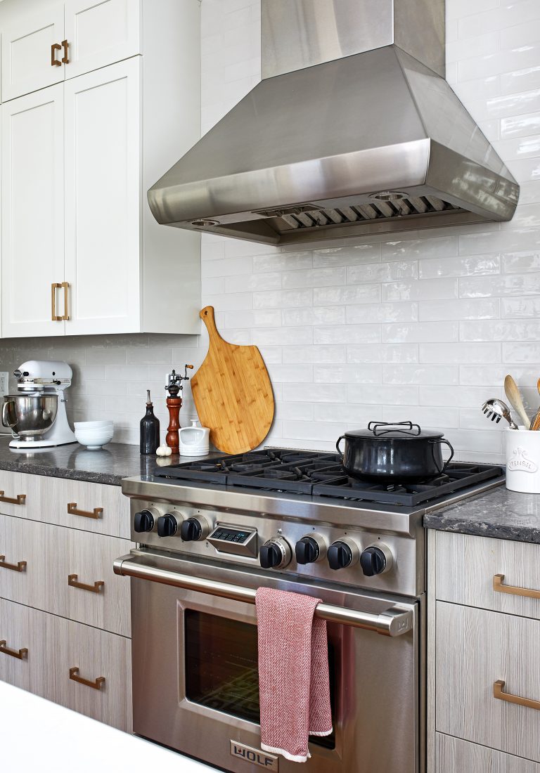 stainless steel gas range and hood white subway tile backsplash