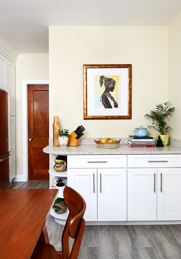 kitchen and dining area with gray wood floors white cabinetry with open shelf storage on end