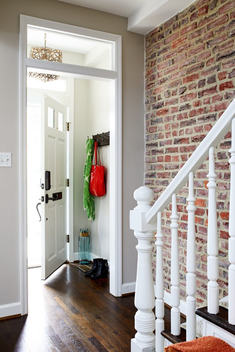 exposed brick wall in entryway along staircase