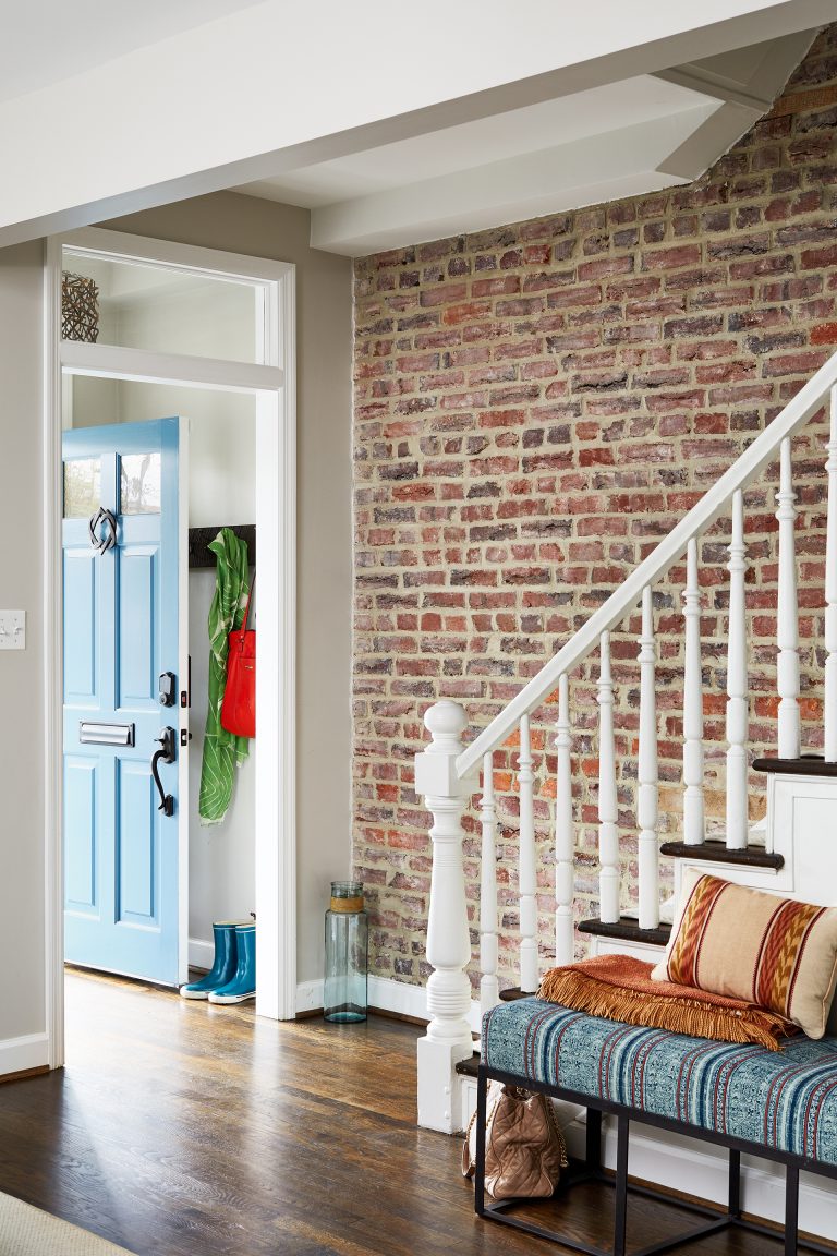 exposed brick wall in entryway along staircase
