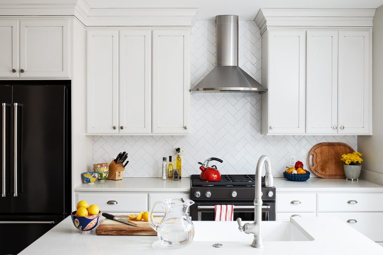 kitchen with white cabinetry and island diamond tile backsplash and black stainless appliances