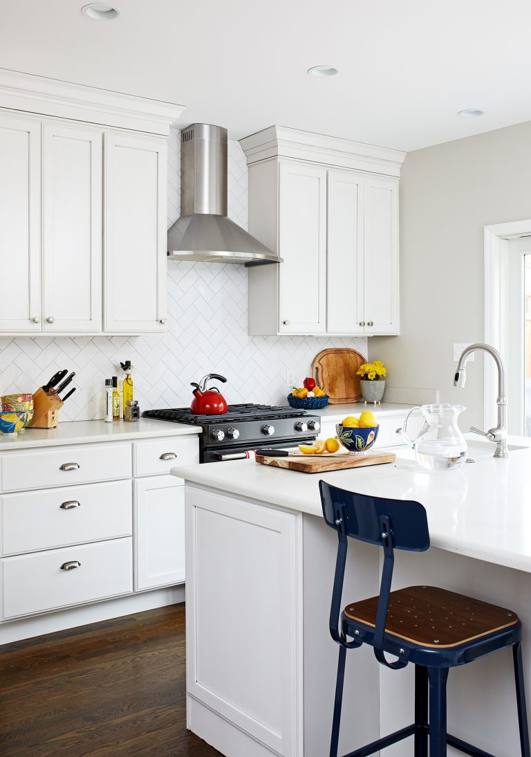 kitchen with dark wood floors and white cabinetry island with seating