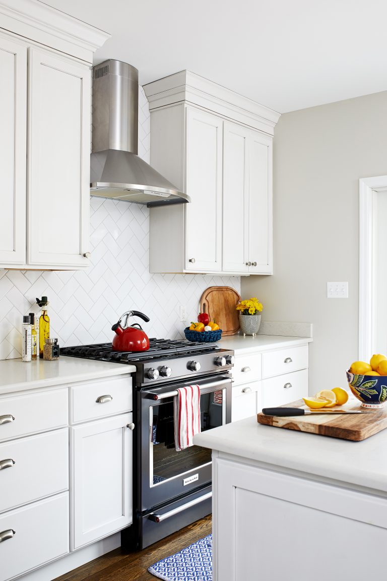 white cabinetry black stainless gas range with stainless steel hood