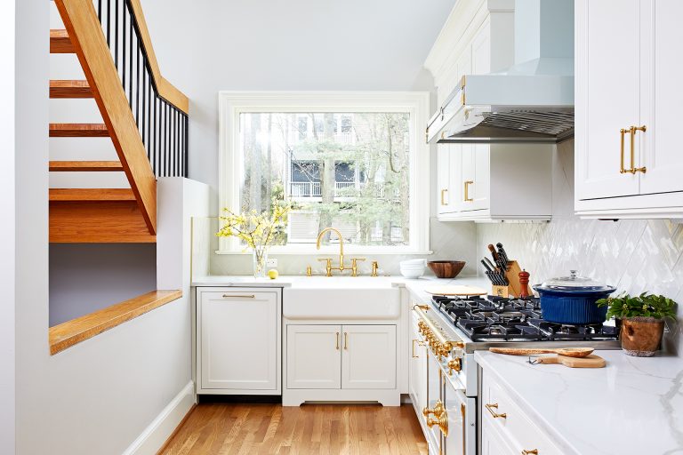 small statement kitchen bright white with gold accents porcelain farmhouse sink wood floors