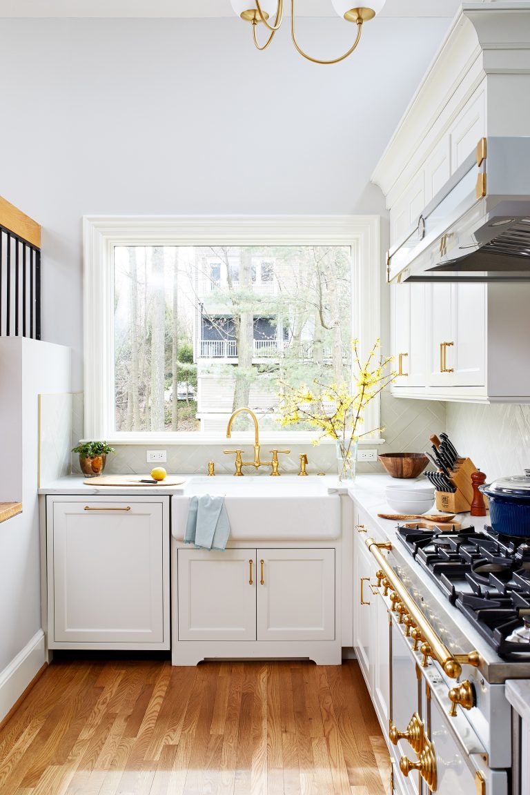 kitchen with large window over farmhouse sink white cabinetry paneled dishwasher