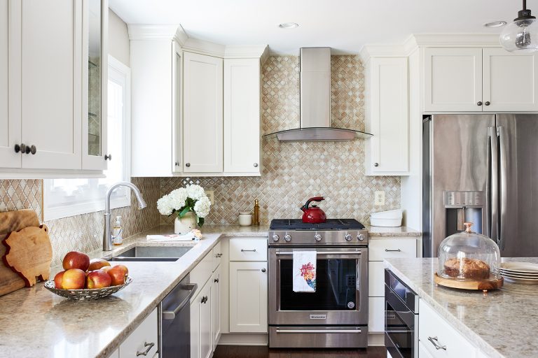 stainless steel gas range and glass hood beige diamond tile backsplash