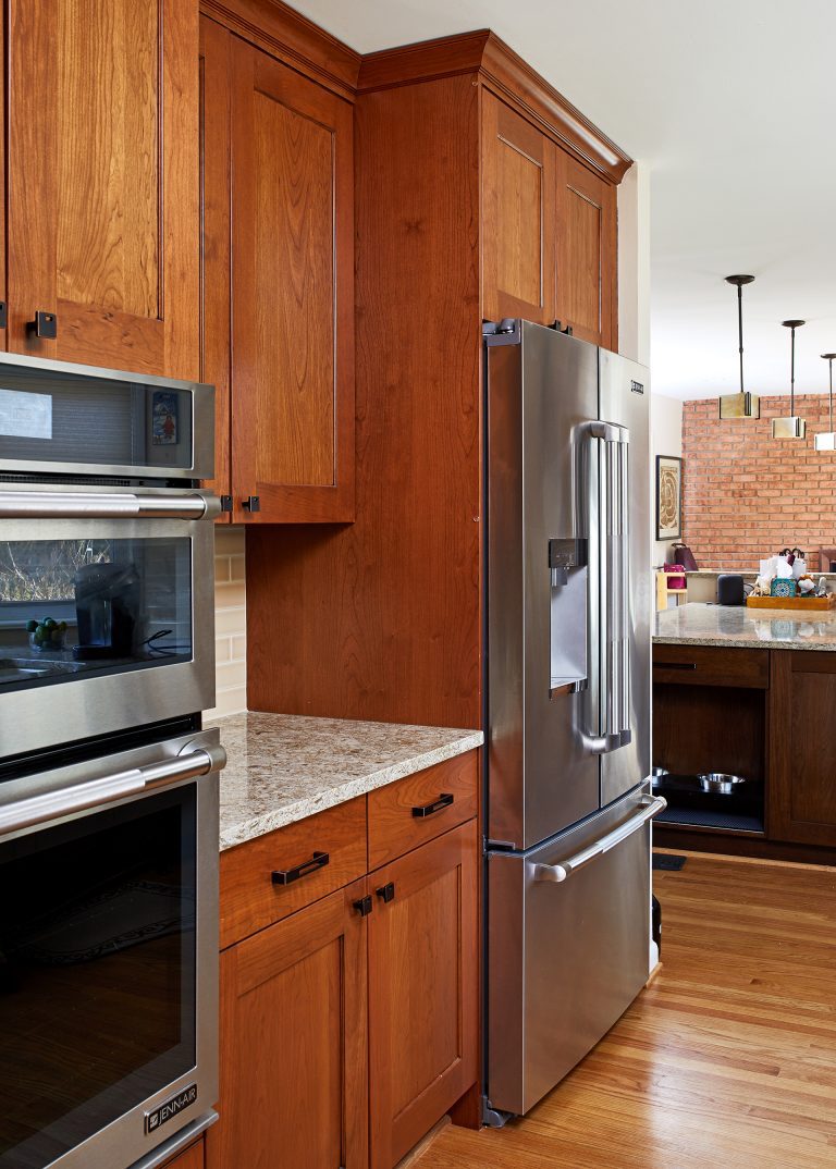 warm tone kitchen natural wood medium stain cabinetry stainless steel appliances