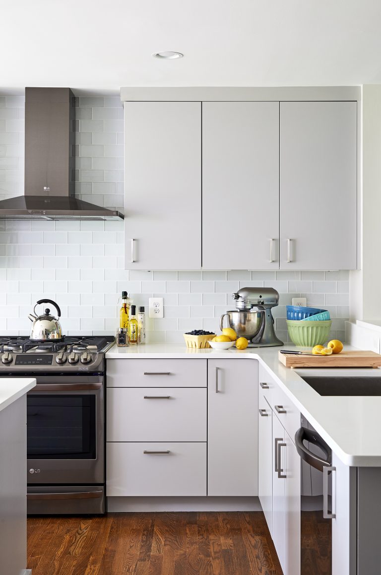 white and gray modern kitchen sleek cabinetry glass tile dark stainless steel appliances