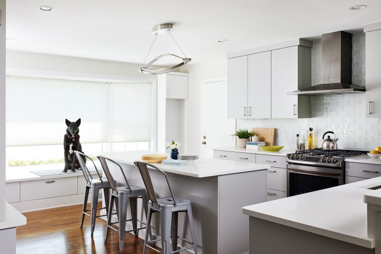 bright modern kitchen white outer cabinetry gray island bay window with built in seat