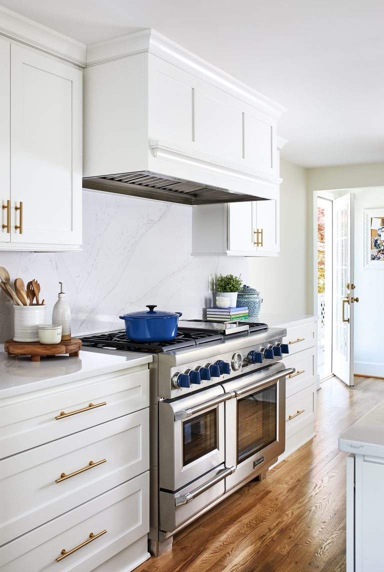 stainless steel gas range with blue knobs paneled range hood