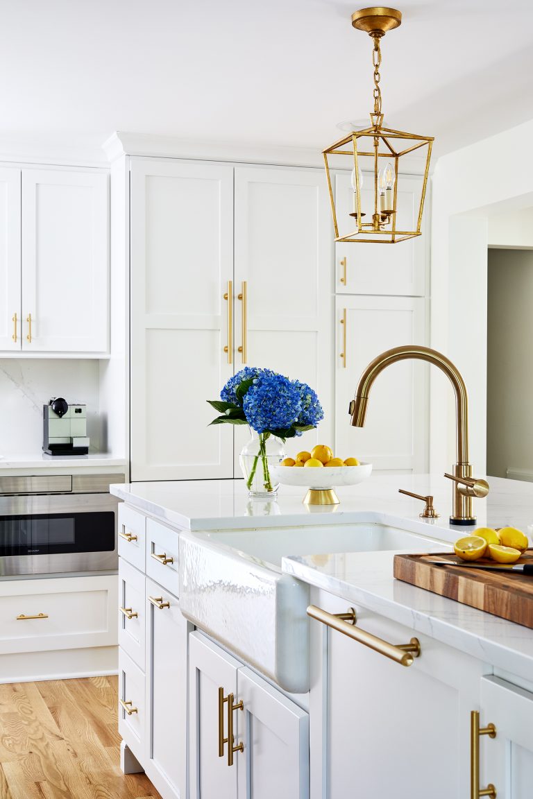 porcelain farmhouse sink in kitchen island with gold fixtures