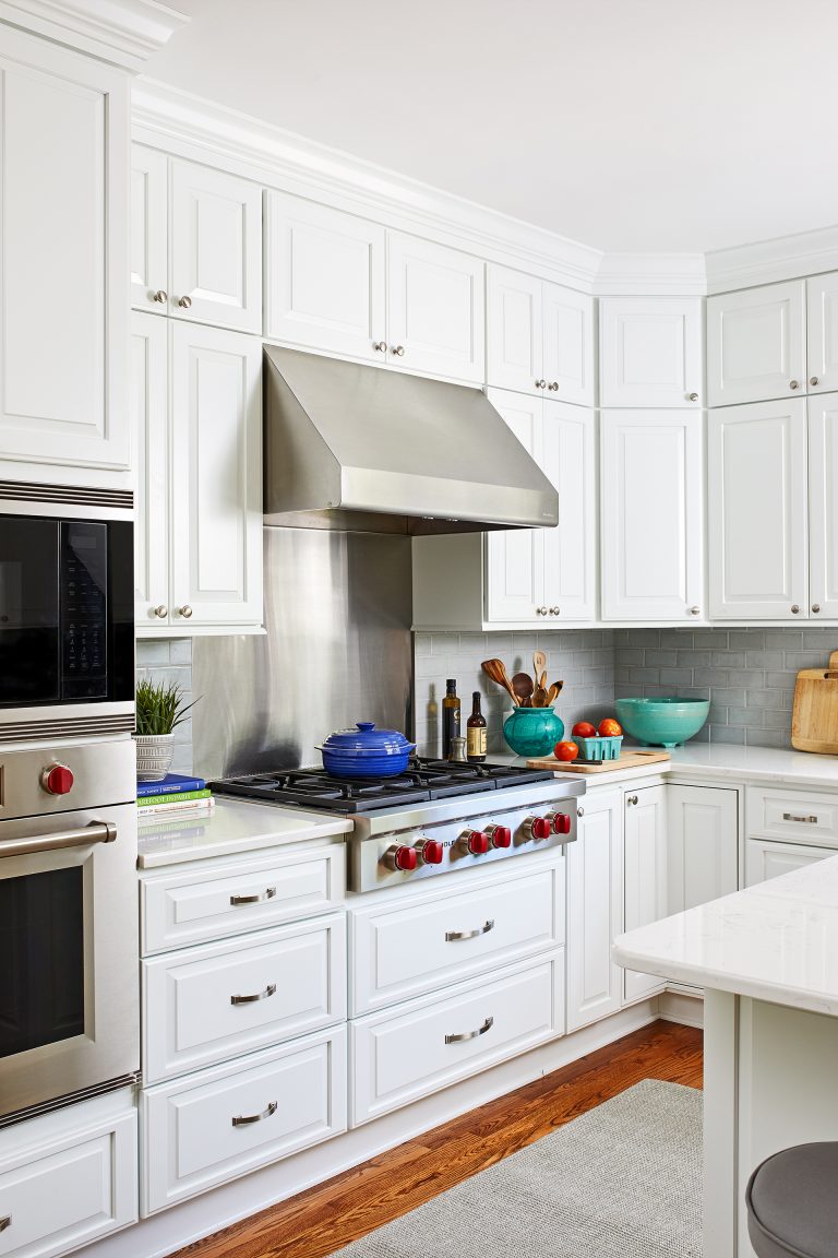 white kitchen with wood floors and stainless steel appliances