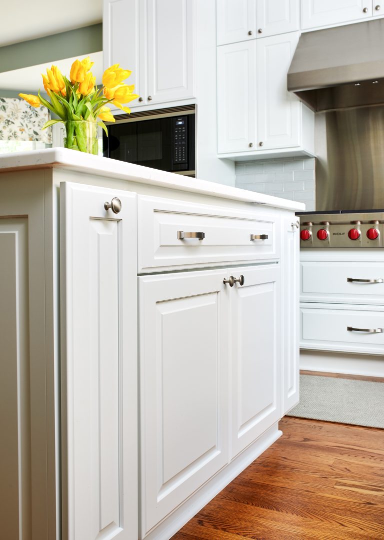 kitchen island with white cabinetry and brushed chrome hardware