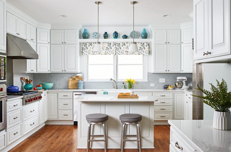 kitchen with white cabinetry wood floors and soft blue color palette island with seating