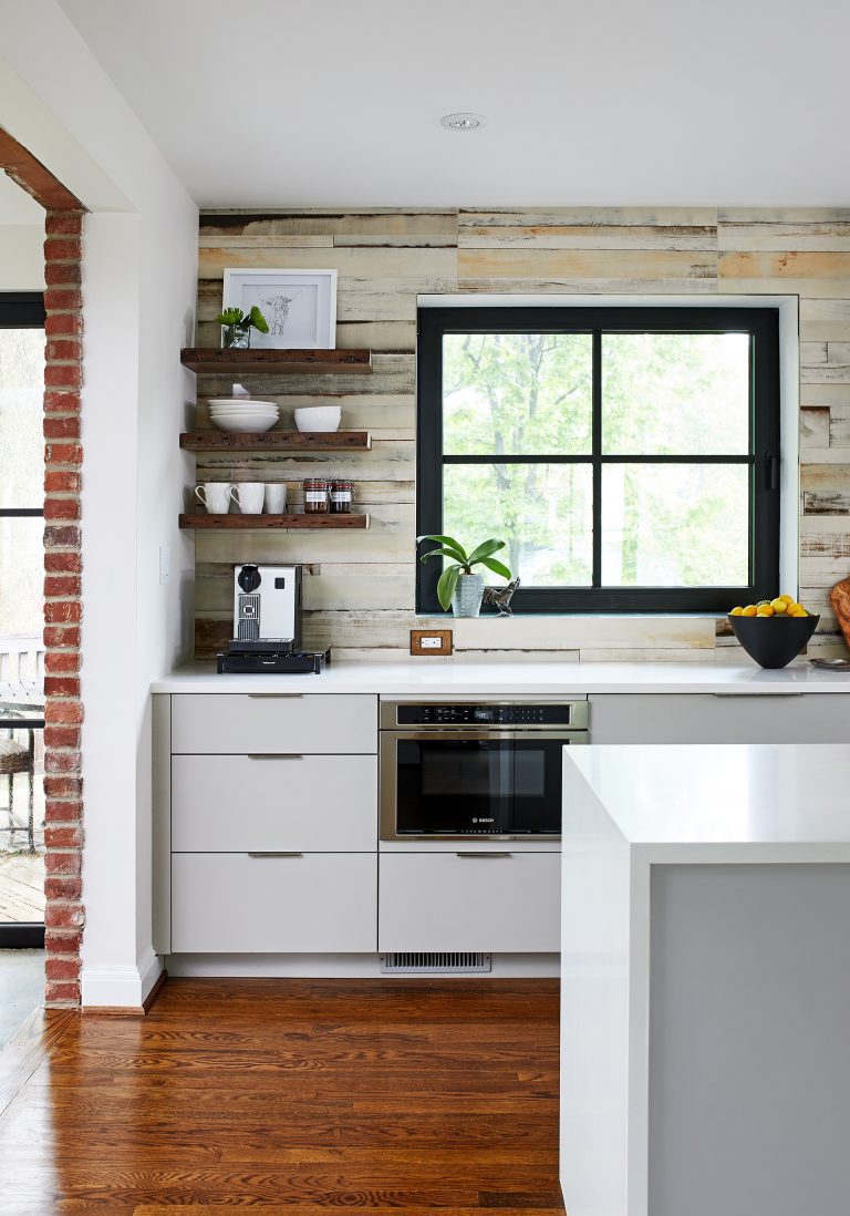 mixed materials living area and kitchen wood exposed brick glass and cement black window panes eclectic style