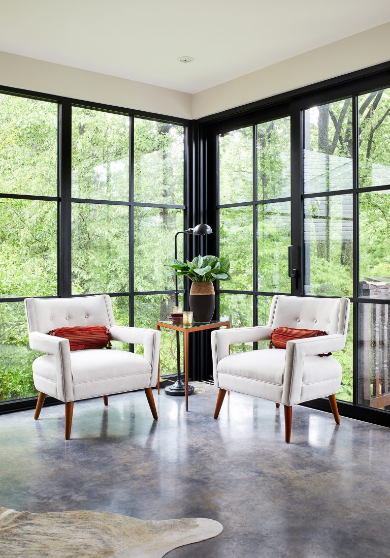 seating area with cement floors and full wall windows with black panes