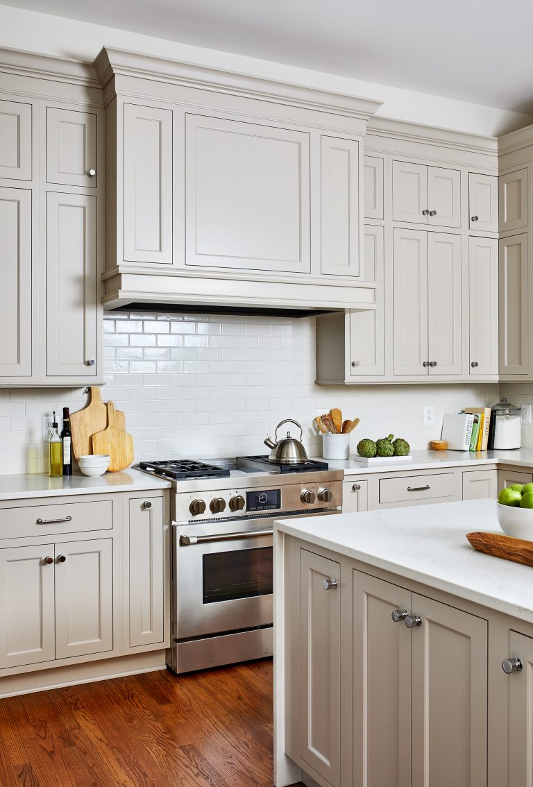 kitchen remodeling with wide custom hood range, subway tile back splash, and waterfall edge island