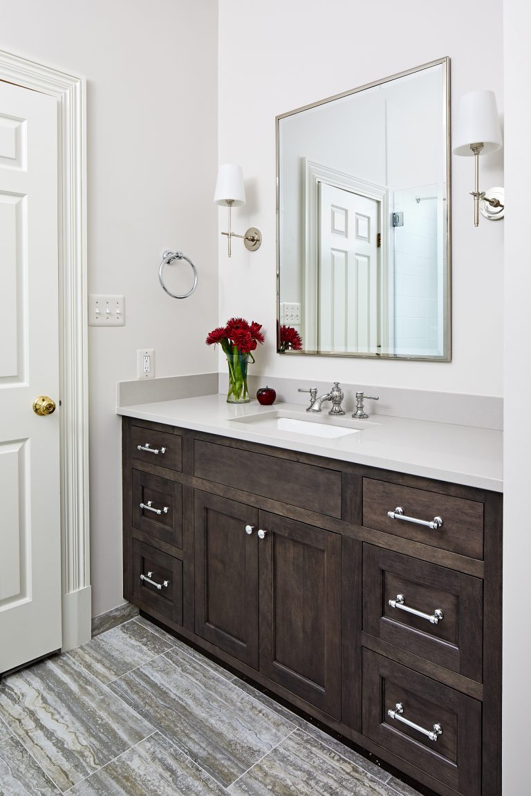 wood vanity with side wall lighting and rectangular mirror