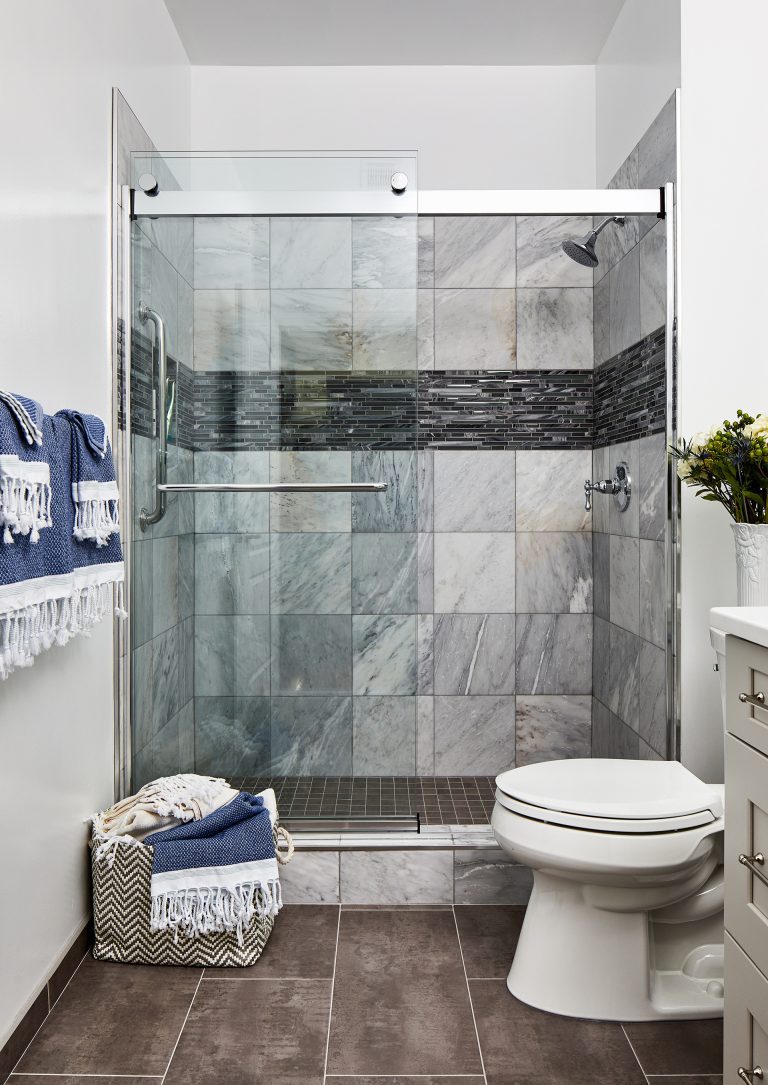 black and grey shower tiles and farmhouse shower glass door