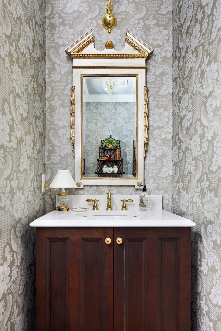 vanity with two doors and gold knobs, white marble top with gold faucets, gold rectangle mirror