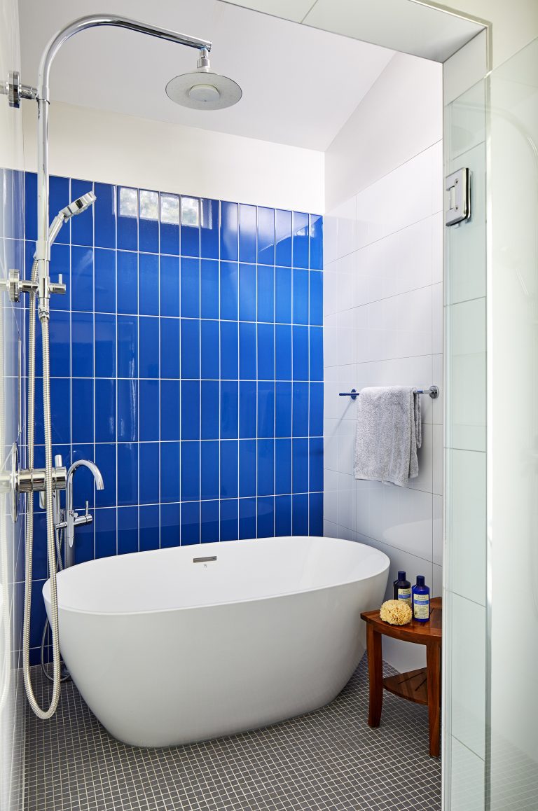 bathroom with white tub and white and blue tiles