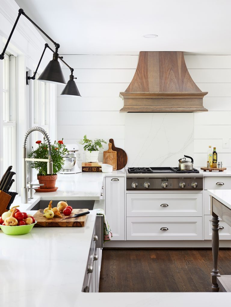 white walls, white cabinets with silver pull handles and wooden dark flooring