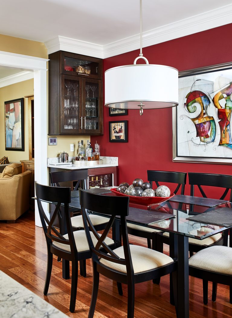 formal red dining room with built in corner wine bar with mini fridge, glass diner room table