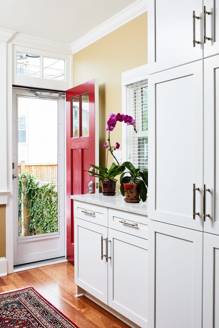 Kitchen exterior red doors, white tall cabinets with pull handles