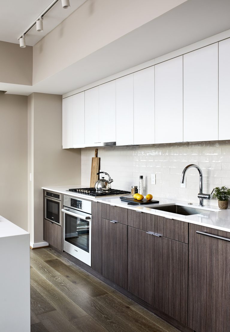 Kitchen remodeling with white brick backsplash, chrome gooseneck faucet and brown cabinets with pull handlers