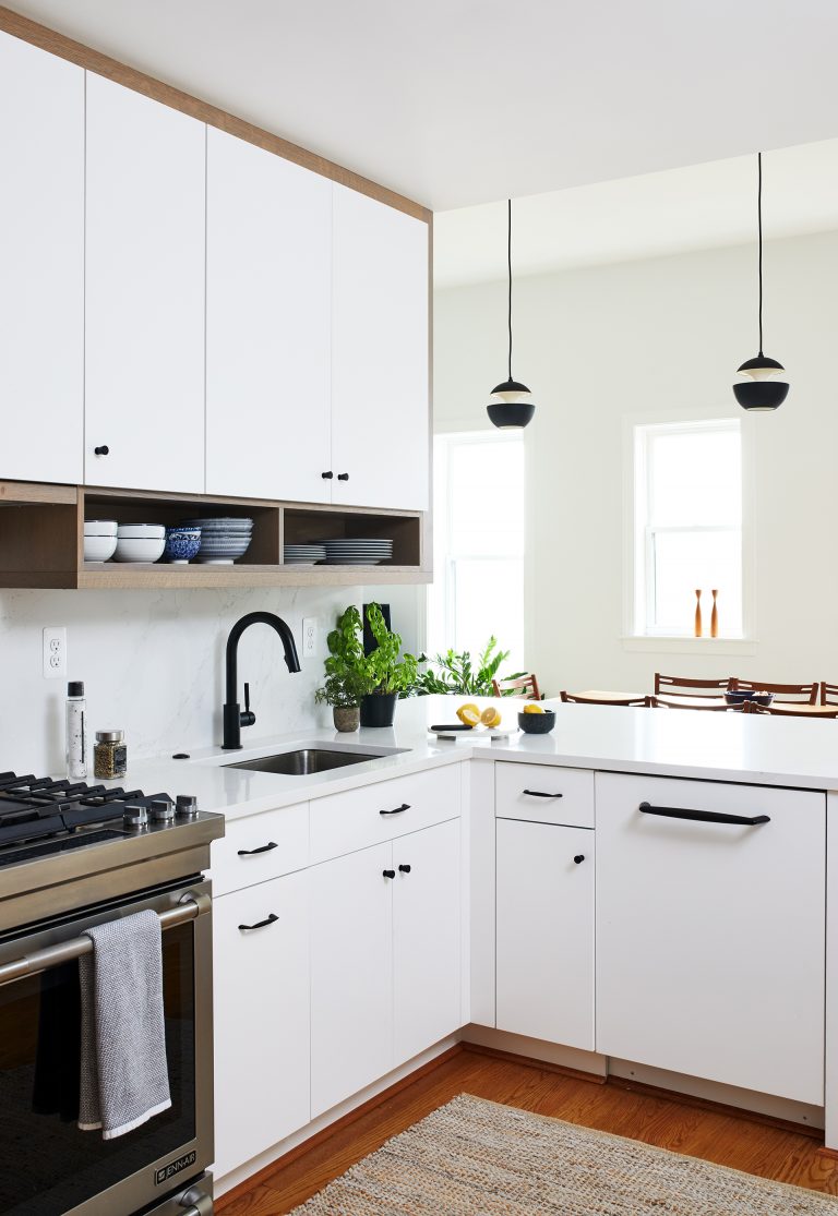 White cabinets with black handles and knobs with a black faucet