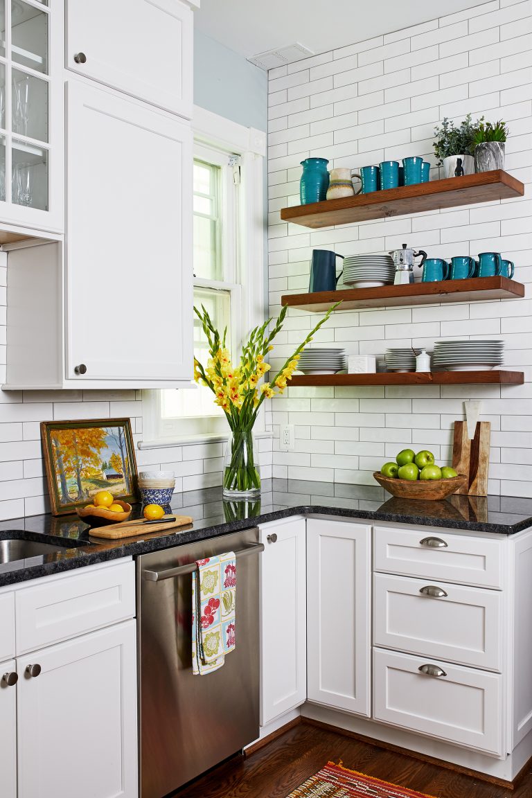 case design kitchen with black counter top with white cabinets, small corner window