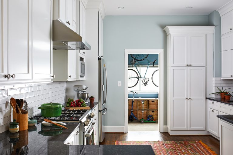 black granite countertop, and garage entry into kitchen custom wall white tall kitchen cabinets