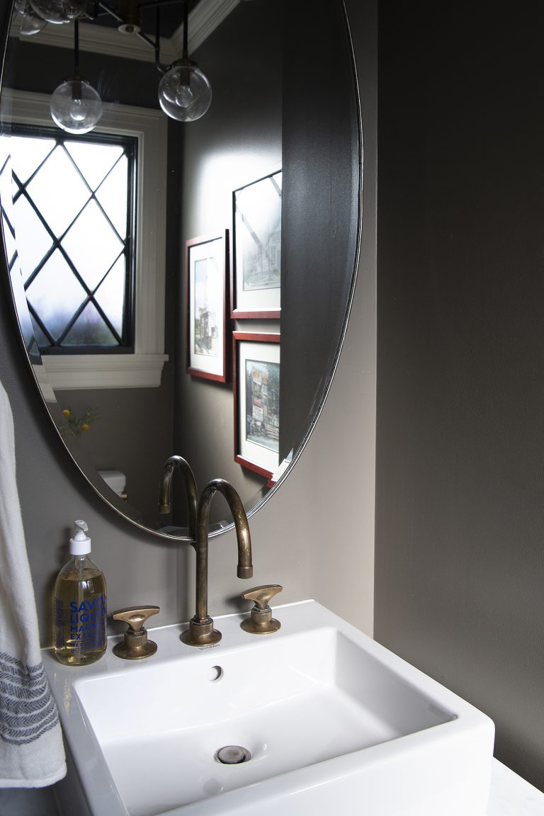 traditional bathroom with large oval mirror above single sink
