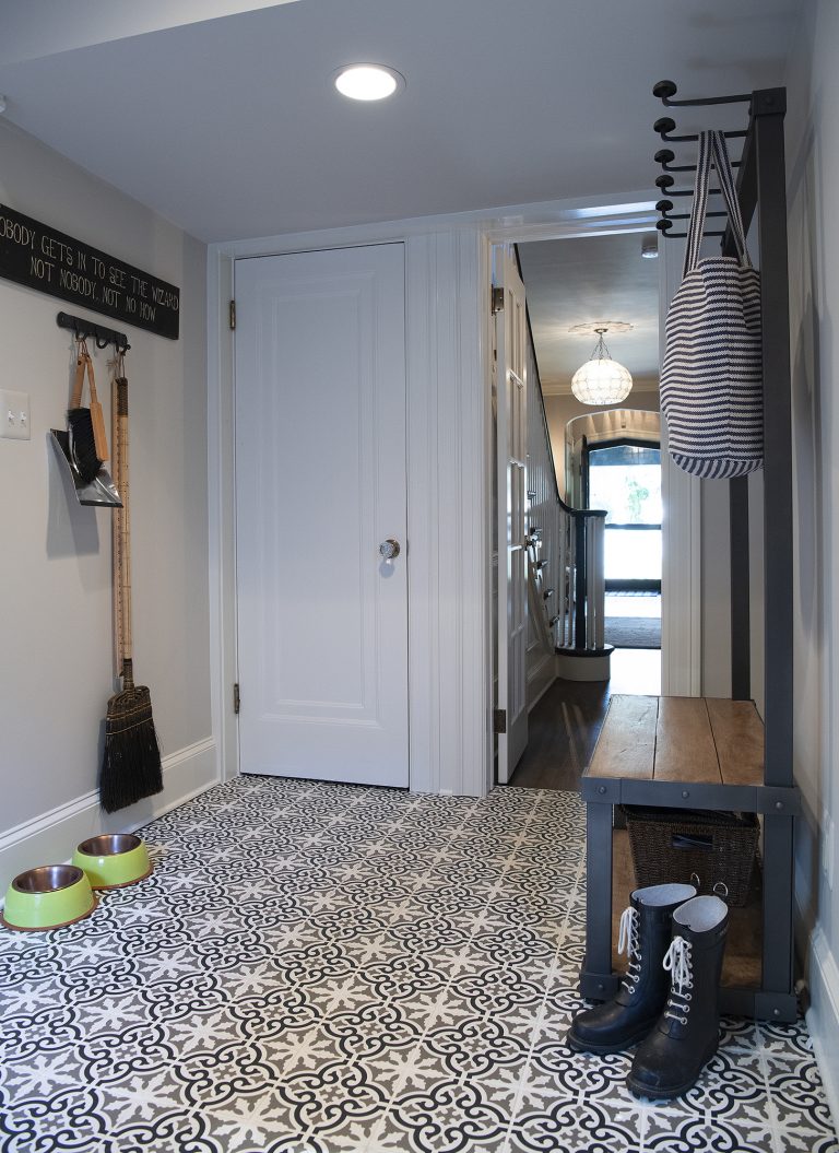 white and black tiles with wooden hallway bench