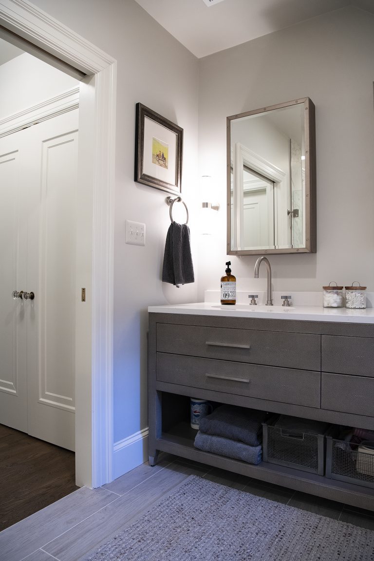bathroom with gray cabinetry open shelving soft color palette