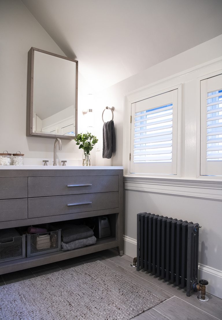 Two small windows above a cast iron hot-water radiator