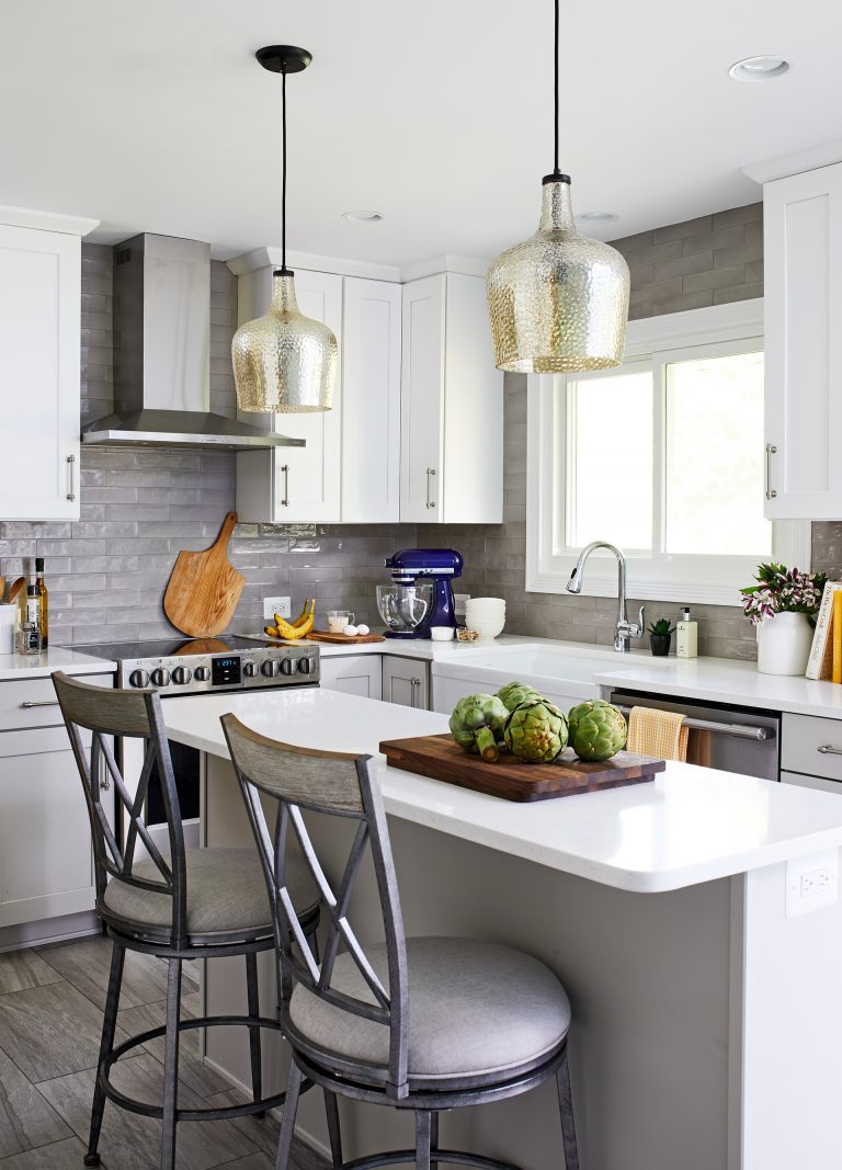 kitchen designer with glass hanging lights over white kitchen island with seating