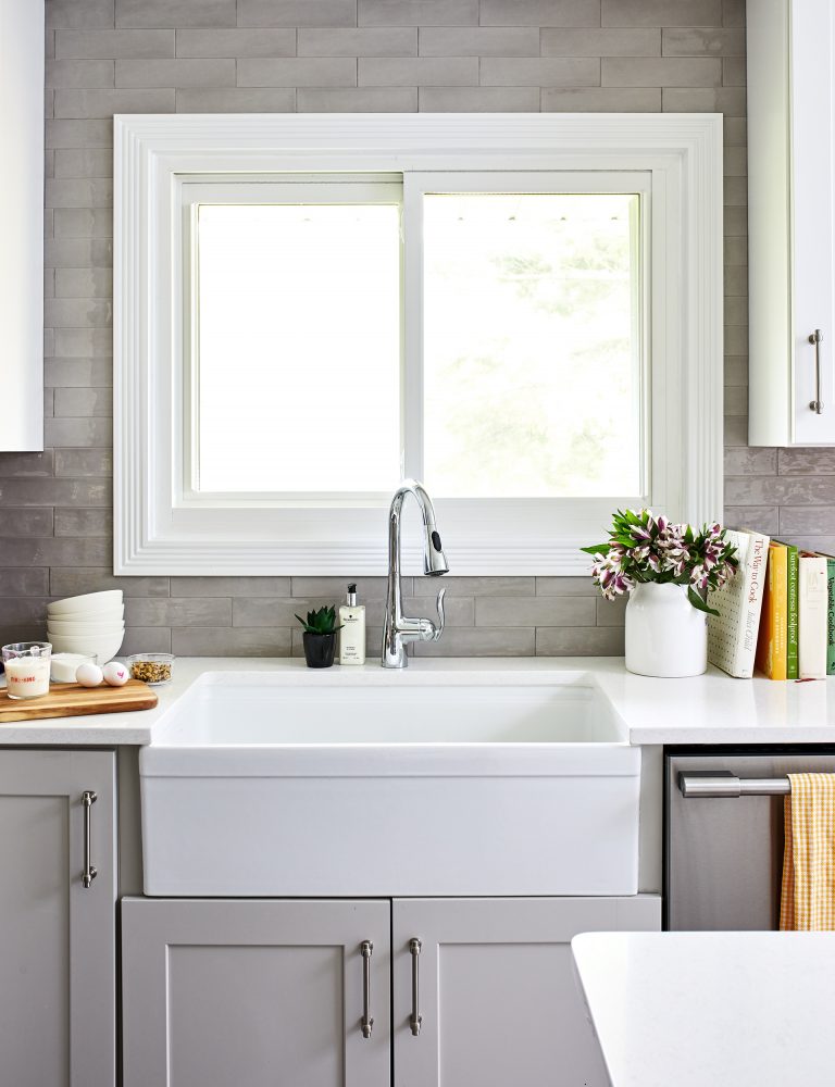 large farmhouse white sink above window with sliding doors