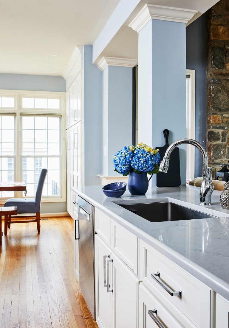 light blue kitchen counter with matching blue walls and white cabinets