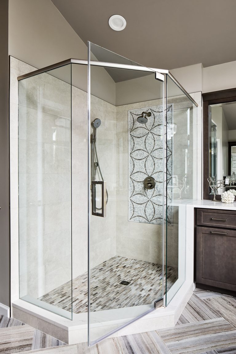 large shower is slightly elevated and enclosed in glass doors panels