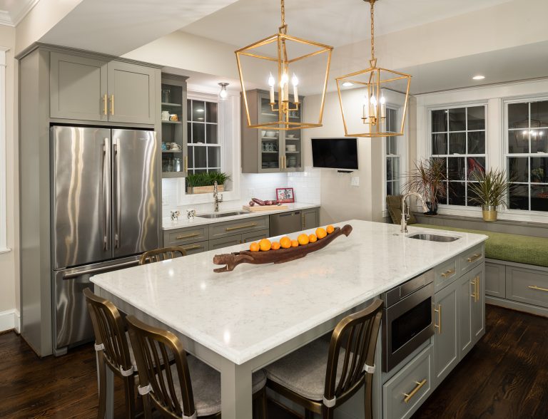 white kitchen island with gold bar stools
