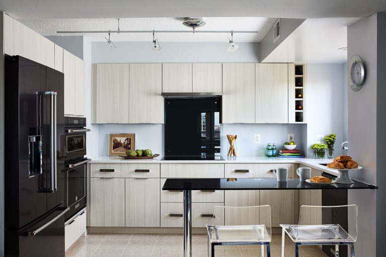 Black appliance with white cabinets and black wall mounted kitchen table with two sits