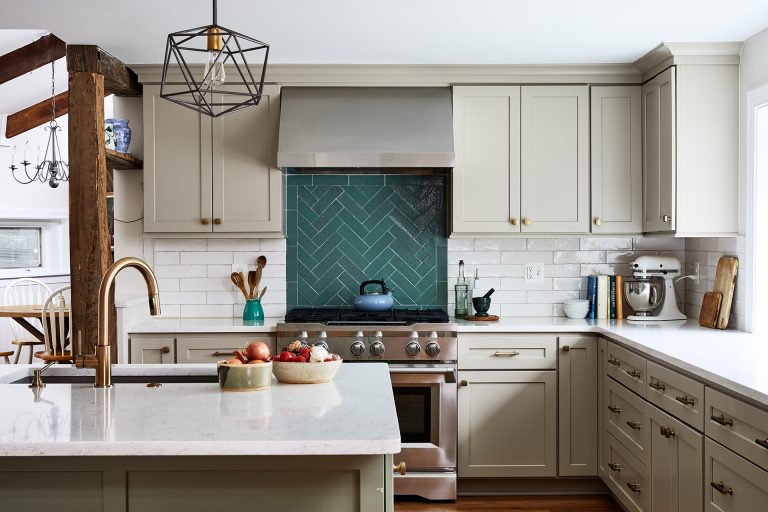 Kitchen lighting above kitchen island with a green backsplash and white cabinets